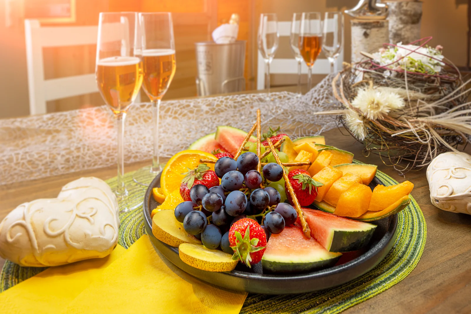 Frischer Obstteller mit Trauben, Melone, Erdbeeren und Sekt